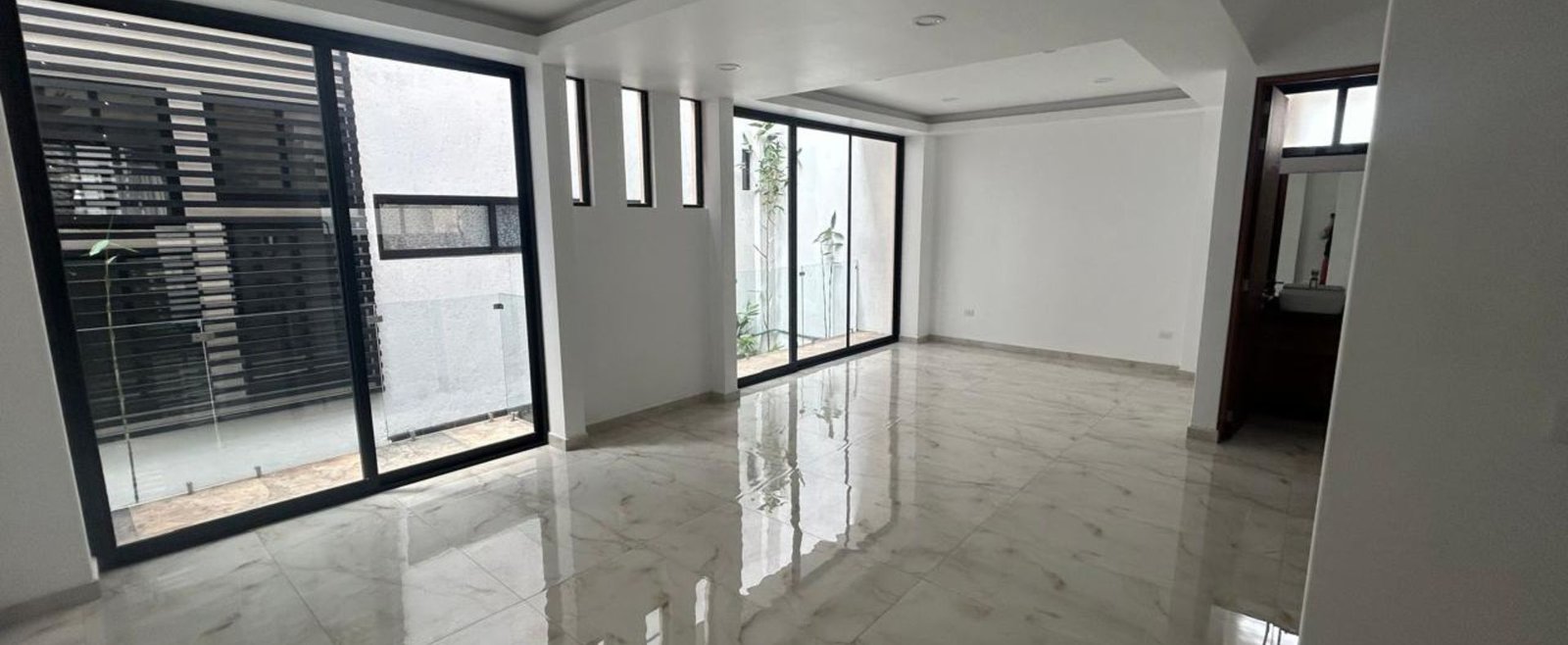 Residencia Aura – sala y comedor amplios con iluminación natural y conexión a la terraza interior